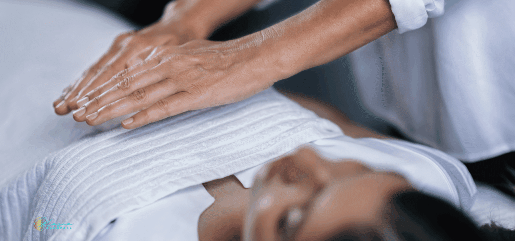 Woman laying on a table receiving energy healing similar to Kasia's work.